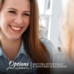 Smiling young woman talking with a caring woman in a cozy space at Options for Women – River Falls
